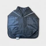 Detail of second-hand Active Canis reflective raincoat 45 cm in black, with clear reflective strips and Velcro fastening. Shows waterproof material and attachment.