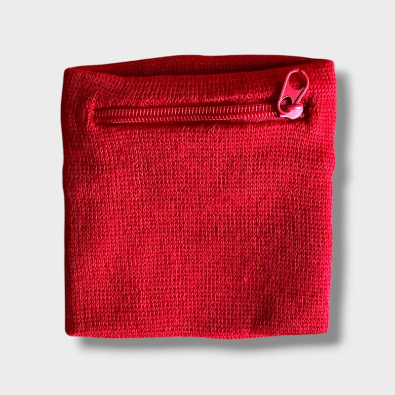 Mini wrist pocket for dog treats in bright red with closed zipper, worn on the wrist